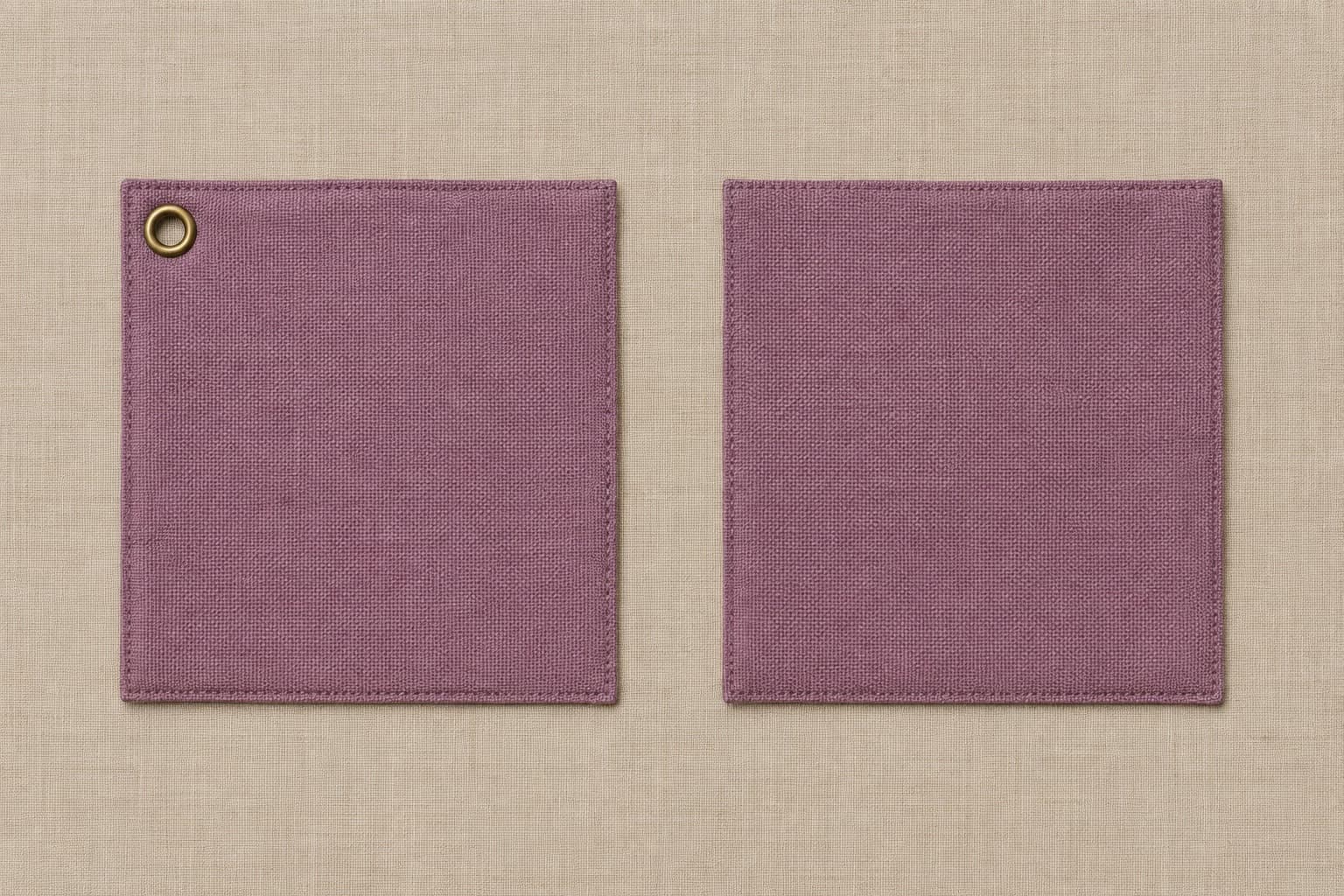 Two identical plain fabric swatches side by side. The left one has a small brass eyelet set into its corner; the right one has none.