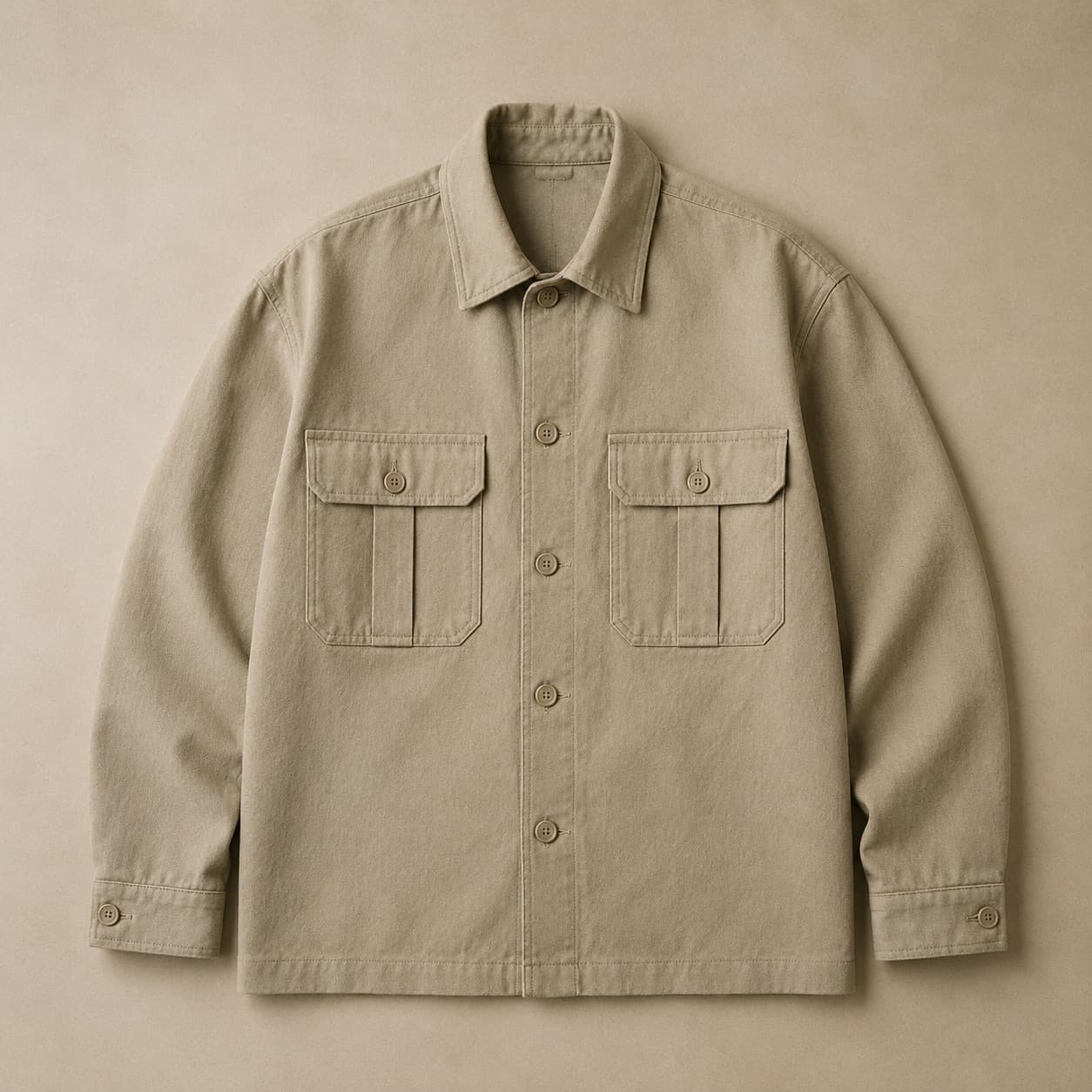 Heavy sand canvas overshirt with two pleated chest pockets laid flat.