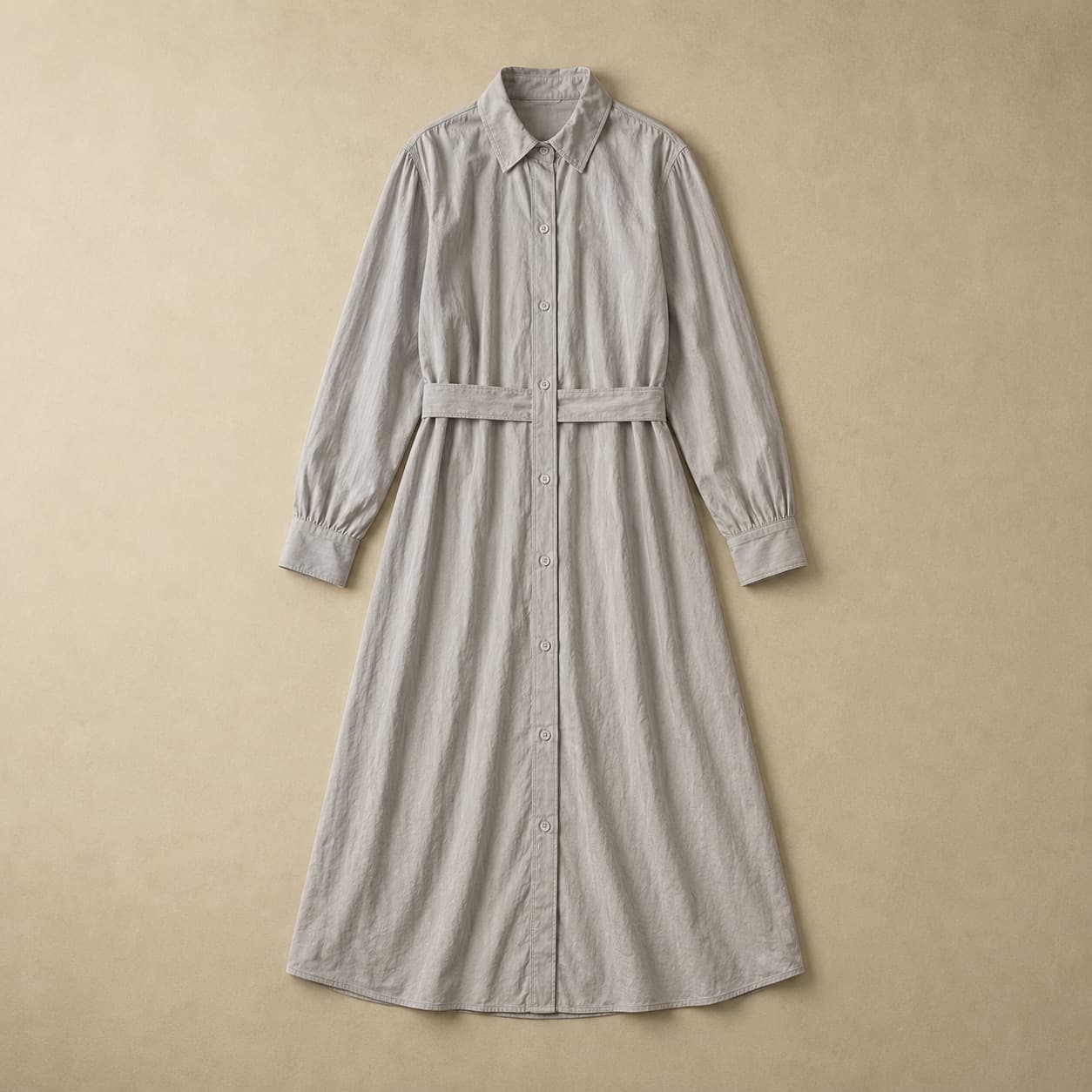 Long pale grey buttoned shirt dress laid flat with a self-fabric belt across the waist.