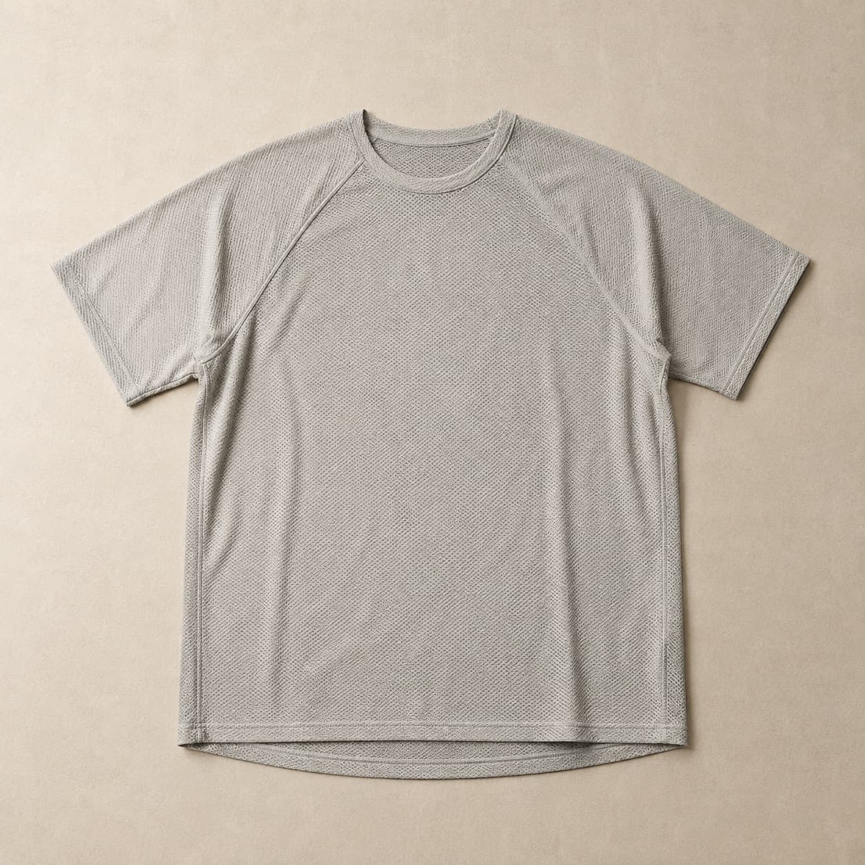 Pale grey short-sleeve knit tee with raglan sleeves laid flat.