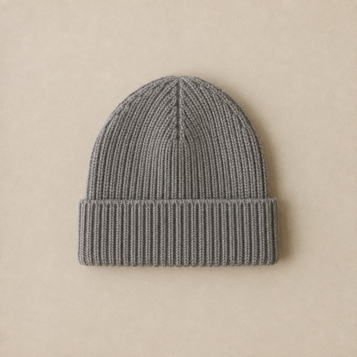 Ribbed grey beanie with a folded cuff photographed flat.