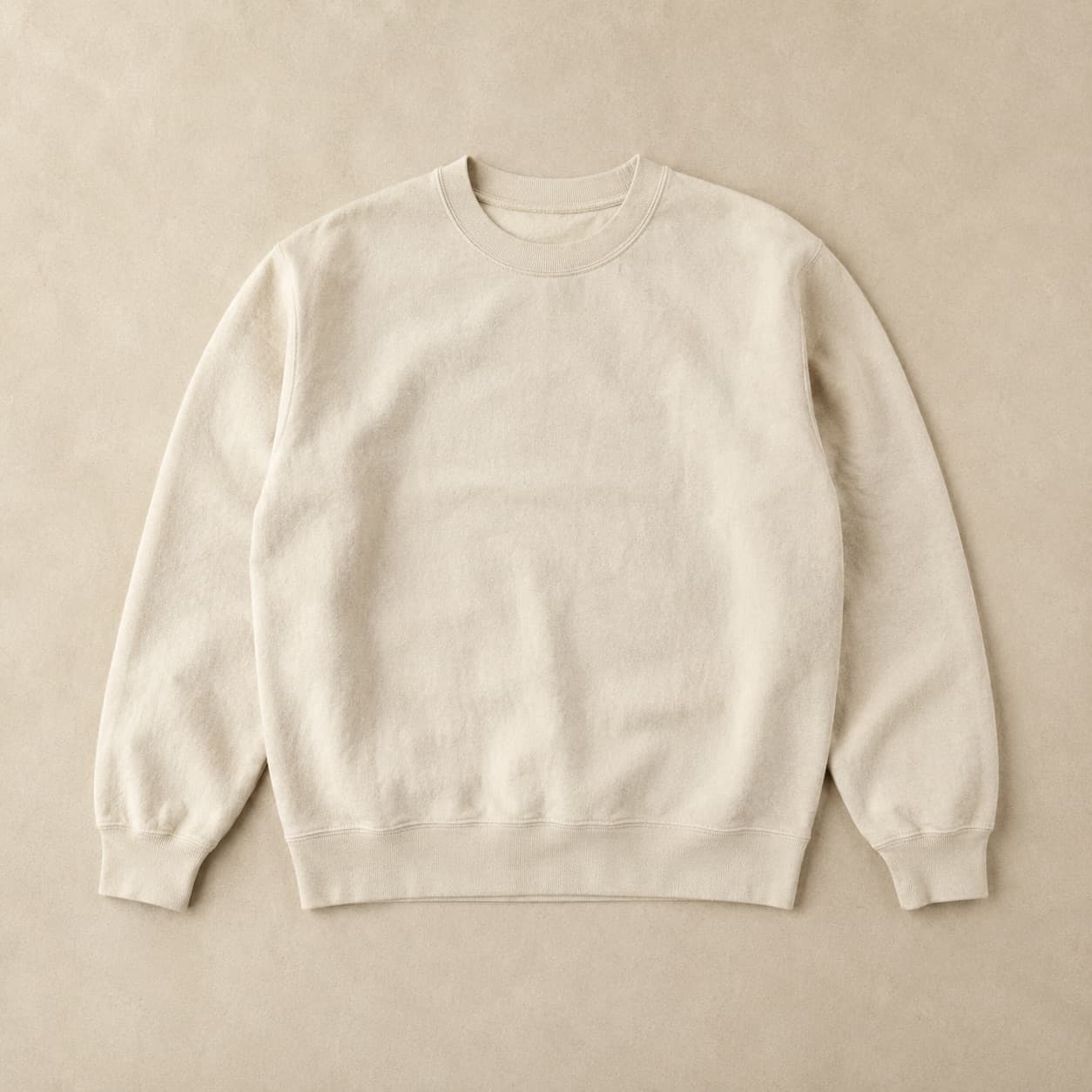 Undyed cream crew-neck sweatshirt laid flat showing slight tonal variation across the body.