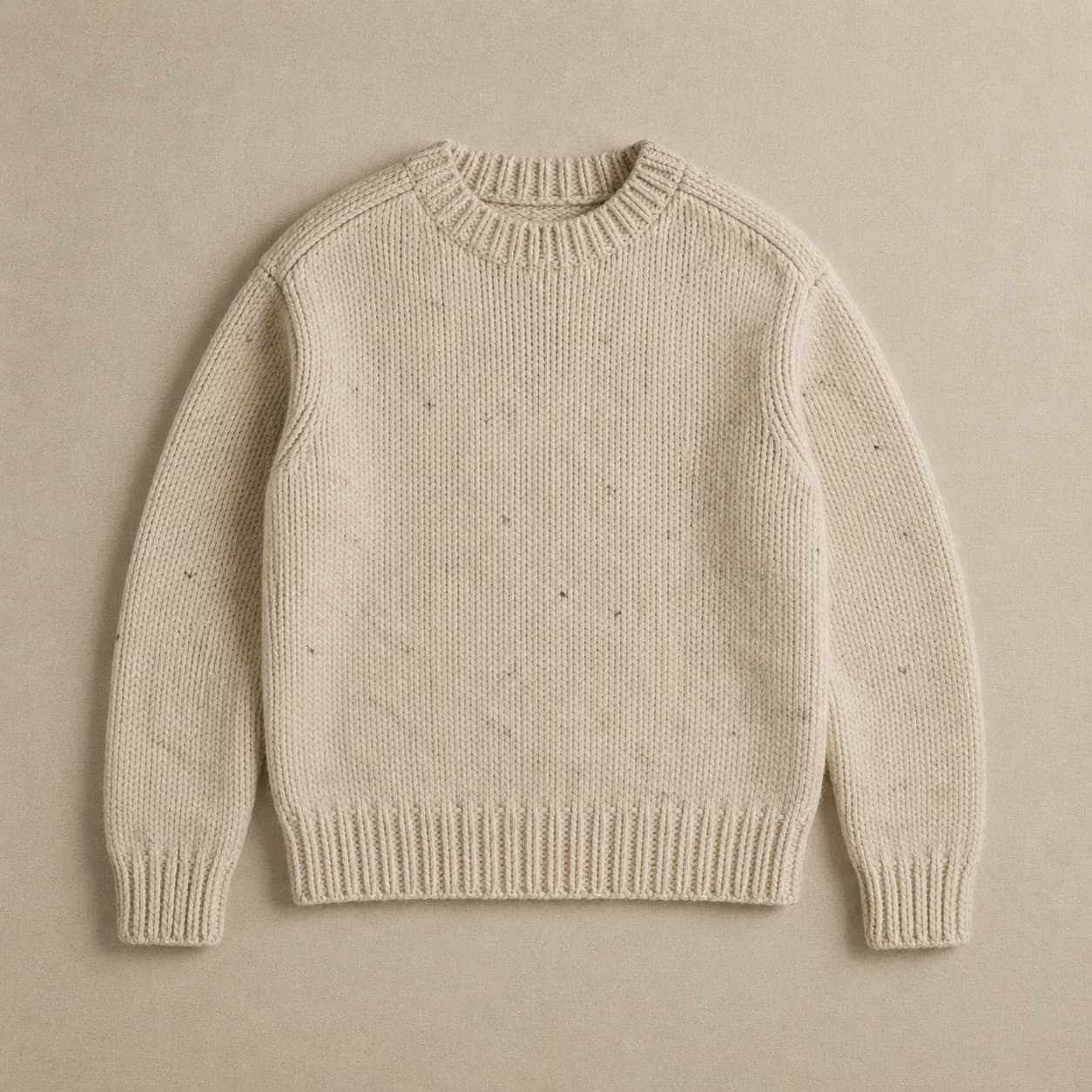 Natural cream wool jumper with scattered darker fibres visible in the knit.